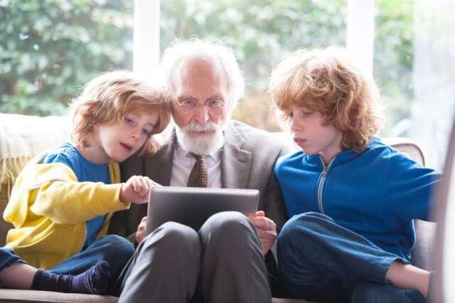 grandfather and grandsons using a digital tablet